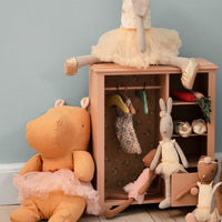 Children's toys and a small wooden cabinet against a light blue wall.