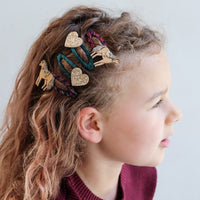 Child with decorative hair accessories on a plain background