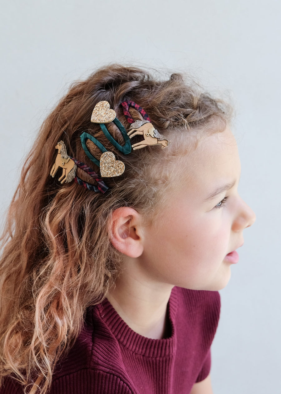 Child with decorative hair accessories on a plain background