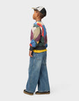 Child wearing a colorful jacket and jeans on a white background