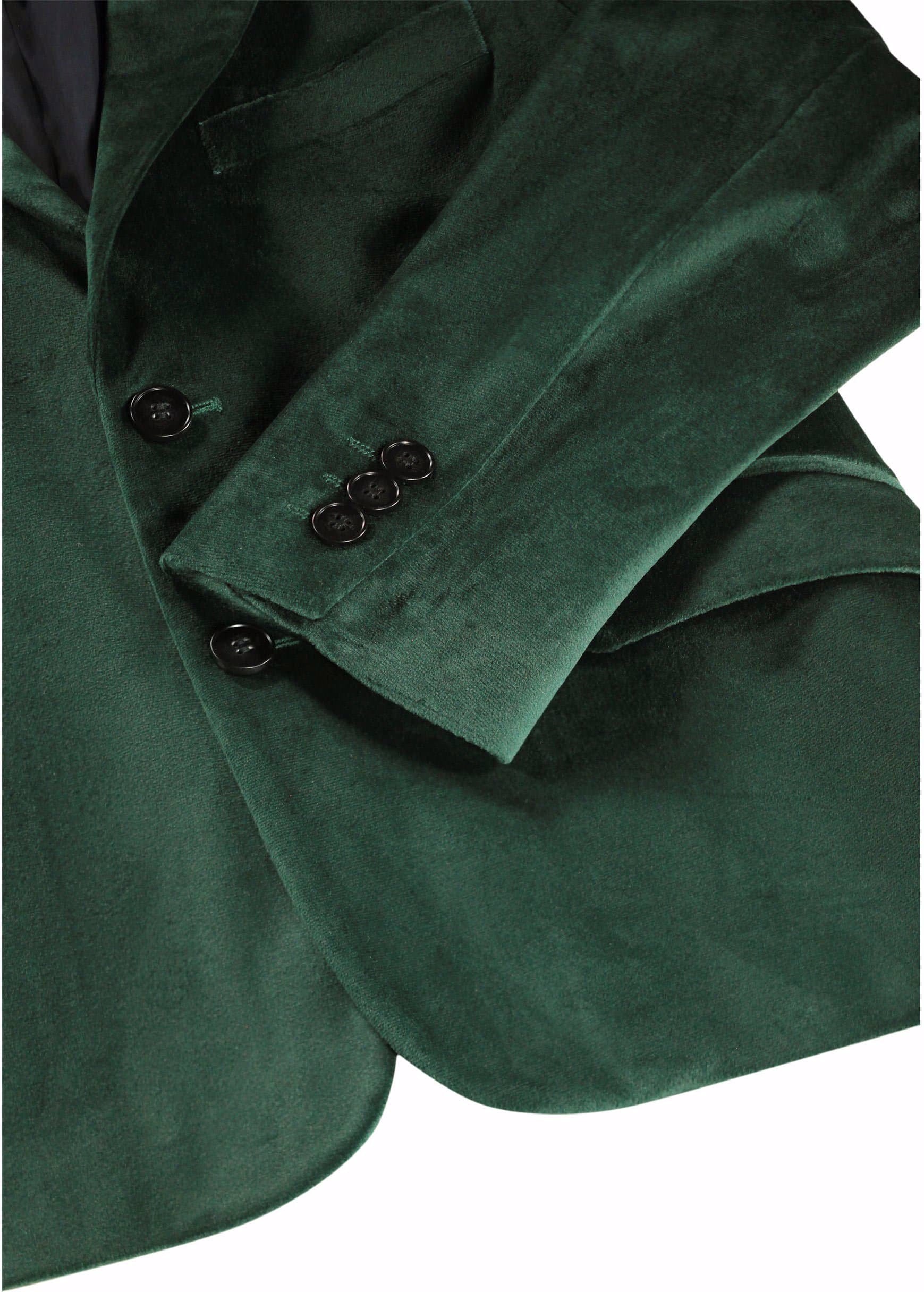 Close-up of a dark green velvet blazer jacket showing the fabric texture, a buttoned cuff with three buttons, and a lapel detail against a white background.