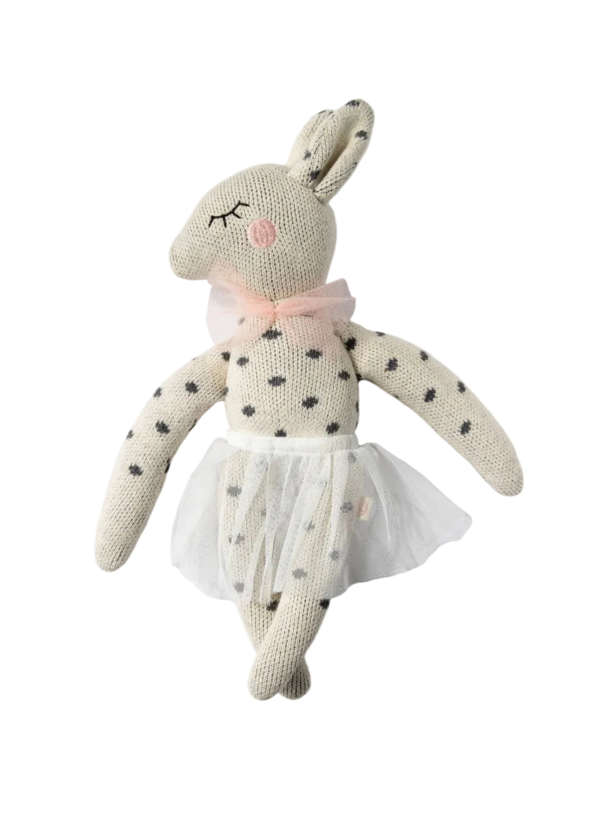 A knitted bunny doll with black polka dots, a pink bow, and a white tutu skirt, photographed against a plain white background.