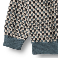 Close-up of a patterned sweater with geometric design on a white background
