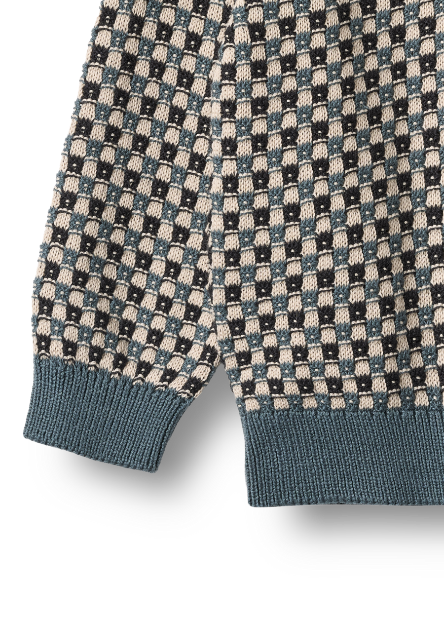 Close-up of a patterned sweater with geometric design on a white background