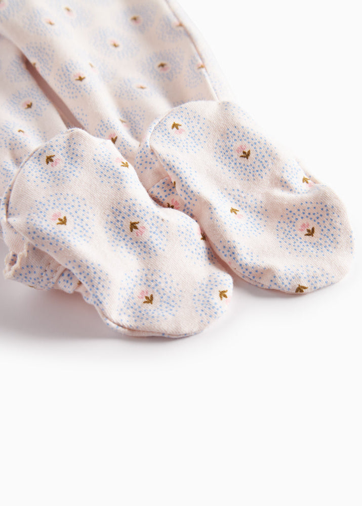 Pair of light pink socks with small floral patterns on a white background
