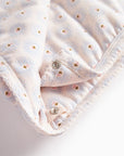 Folded fabric with small buttons on a light background