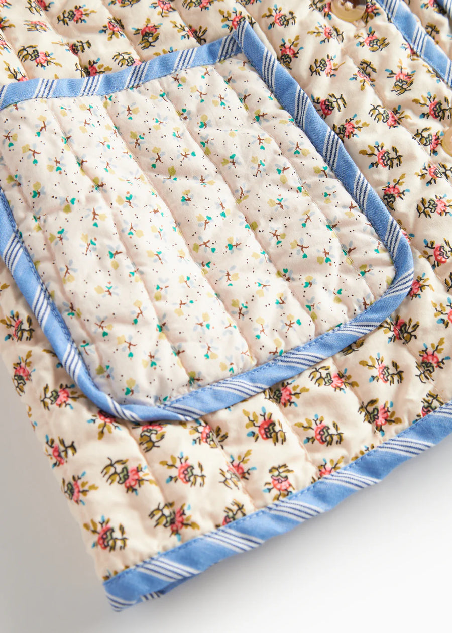 Floral-patterned quilt with blue trim on a white background