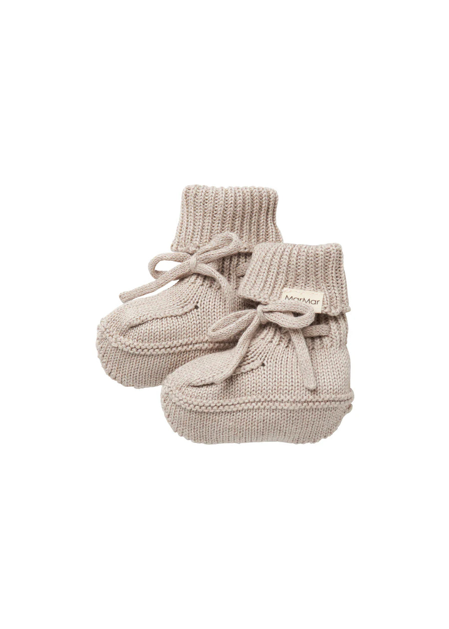Pair of beige knitted baby booties on a white background
