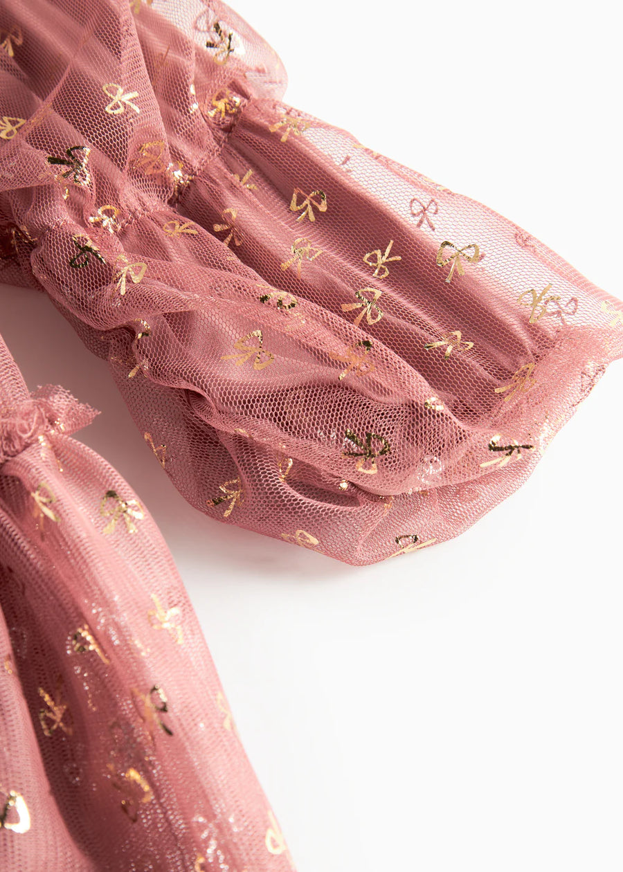 Pink tulle fabric with gold bow patterns on a white background
