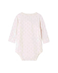 A light pink long-sleeve baby bodysuit with a delicate repeating pattern of small gold cartoon faces, shown flat against a white background.