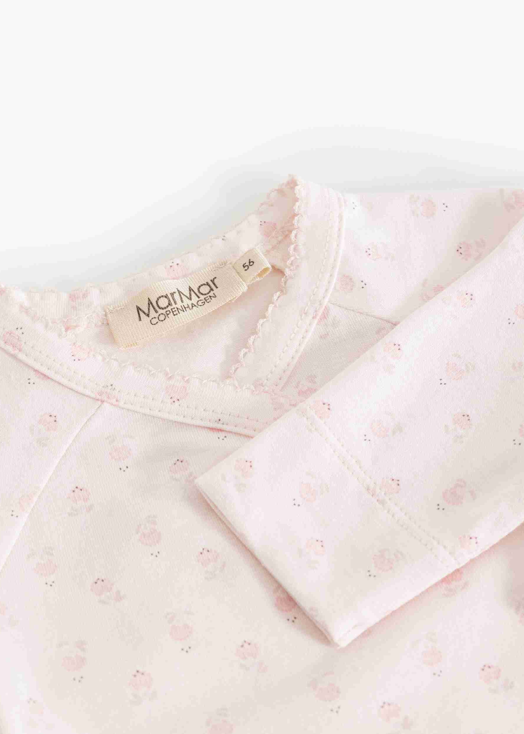 A close-up of a baby long-sleeve top by Marni, featuring a pale pink and white micro-floral pattern, a scalloped neckline, and a visible brand label.