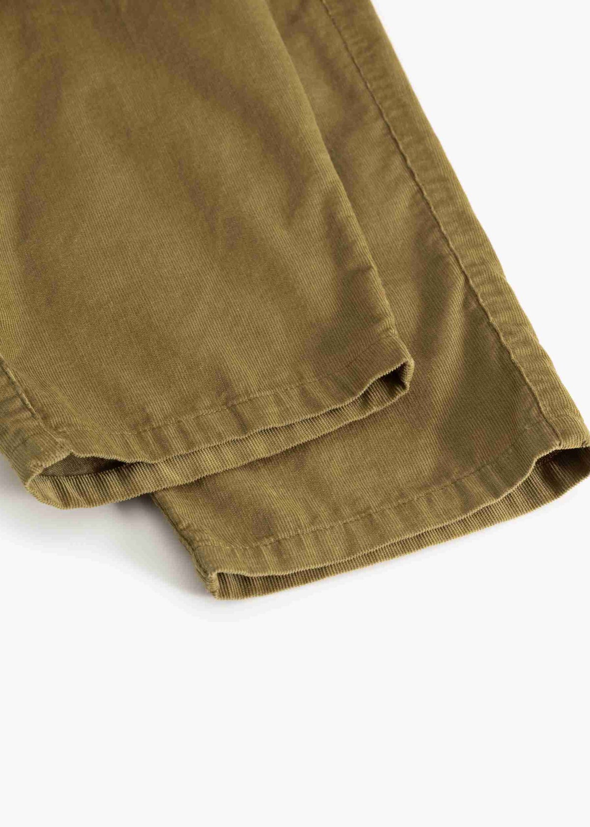 Close-up of folded olive green pants fabric on a plain white background.