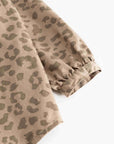 Close-up of a beige and olive green leopard print fabric sleeve with a gathered elastic cuff, shown on a plain white background.