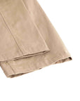 Close-up of folded khaki fabric with visible stitching and hem, shown on a plain white background.