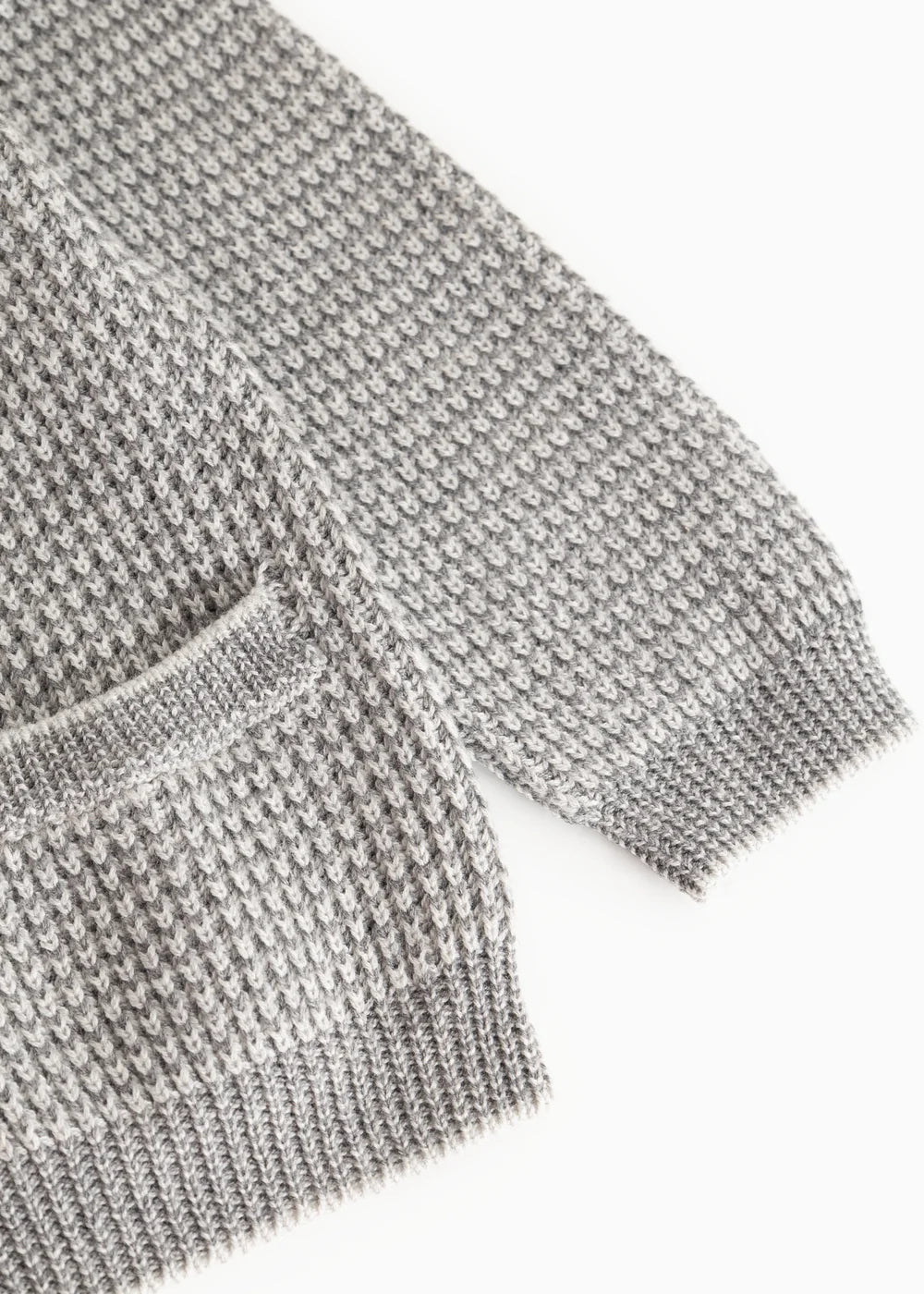 Close-up of a gray knit sweater on a white background