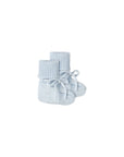 A pair of light blue knit baby booties with ribbed cuffs and matching tie-front laces, photographed on a clean white background.