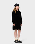 Young girl wearing a black coat and beret on a white background