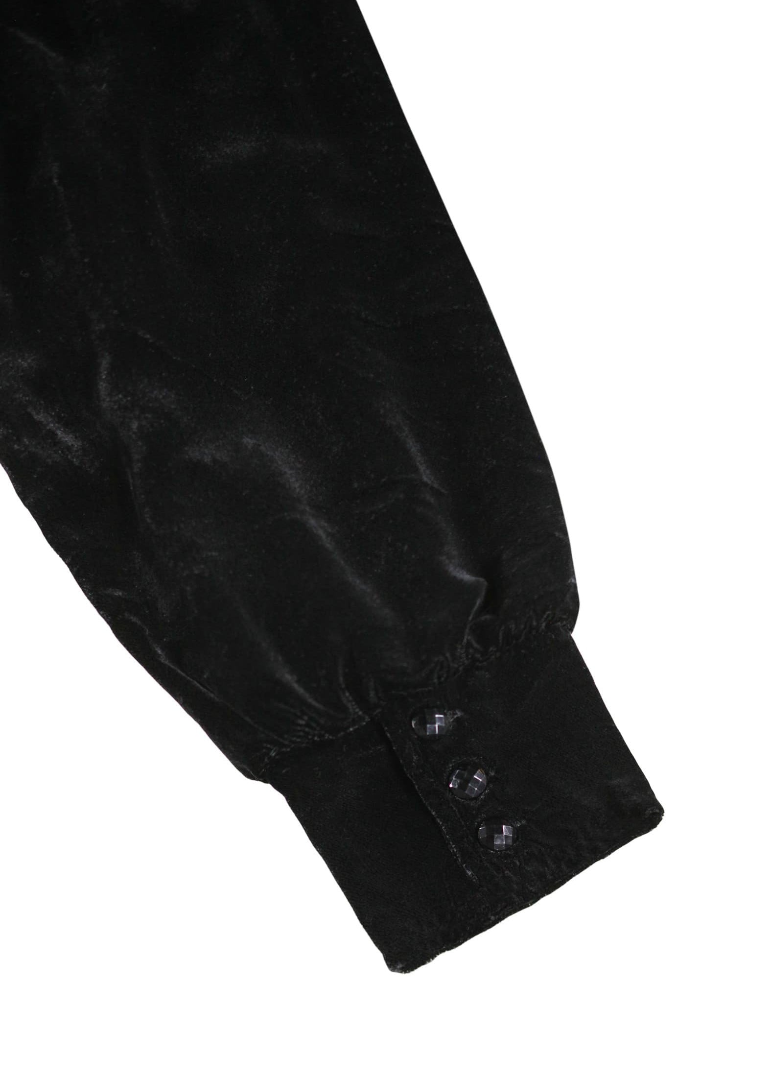 Close-up of a black velvet garment with buttons on a white background