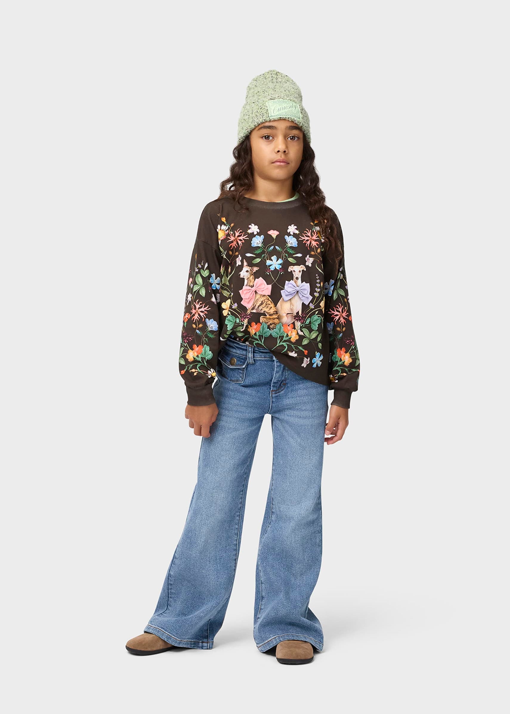 Person wearing a floral sweater and blue jeans on a white background