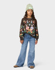Person wearing a floral sweater and blue jeans on a white background