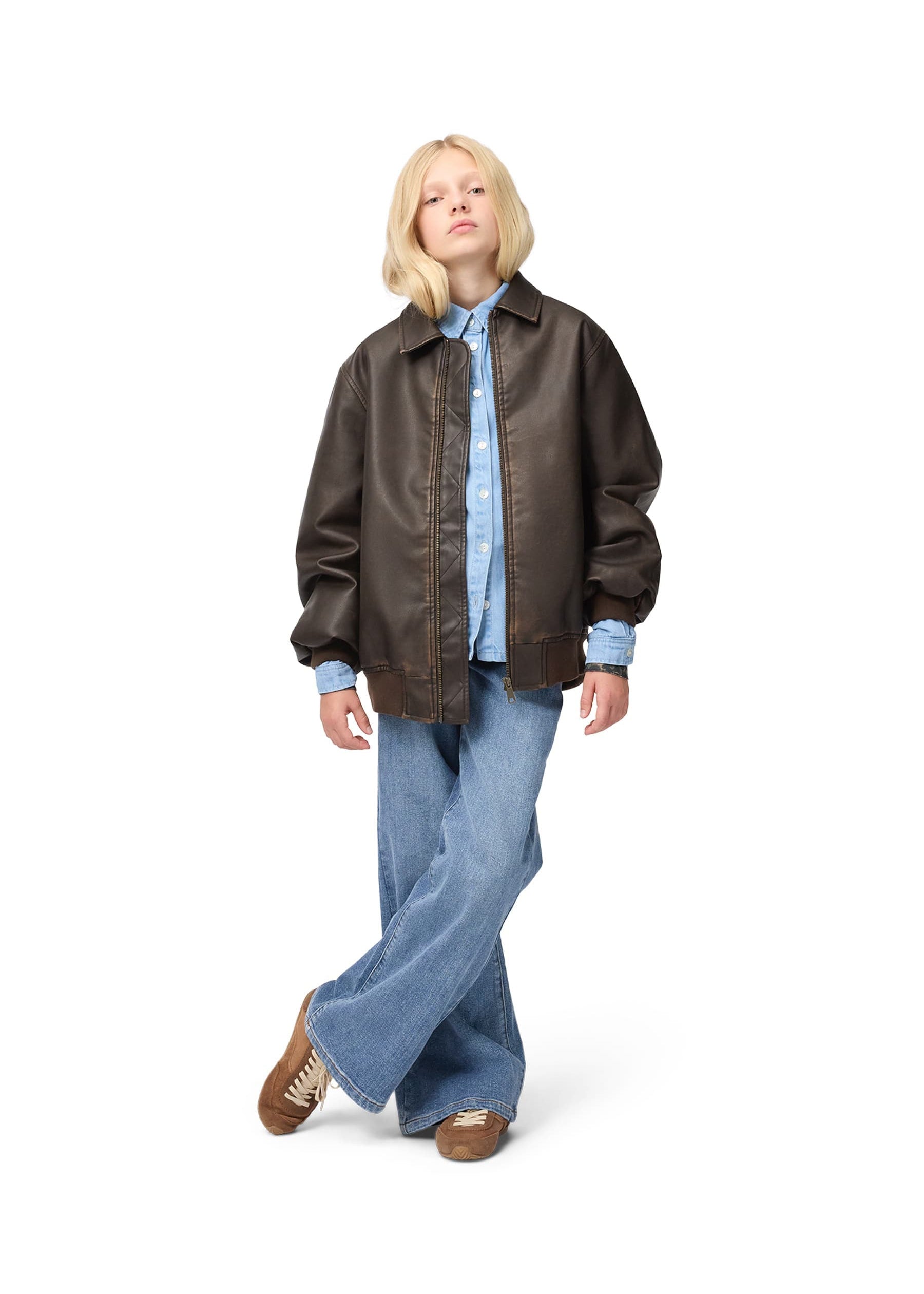 Person wearing a brown leather jacket, blue shirt, and jeans on a white background