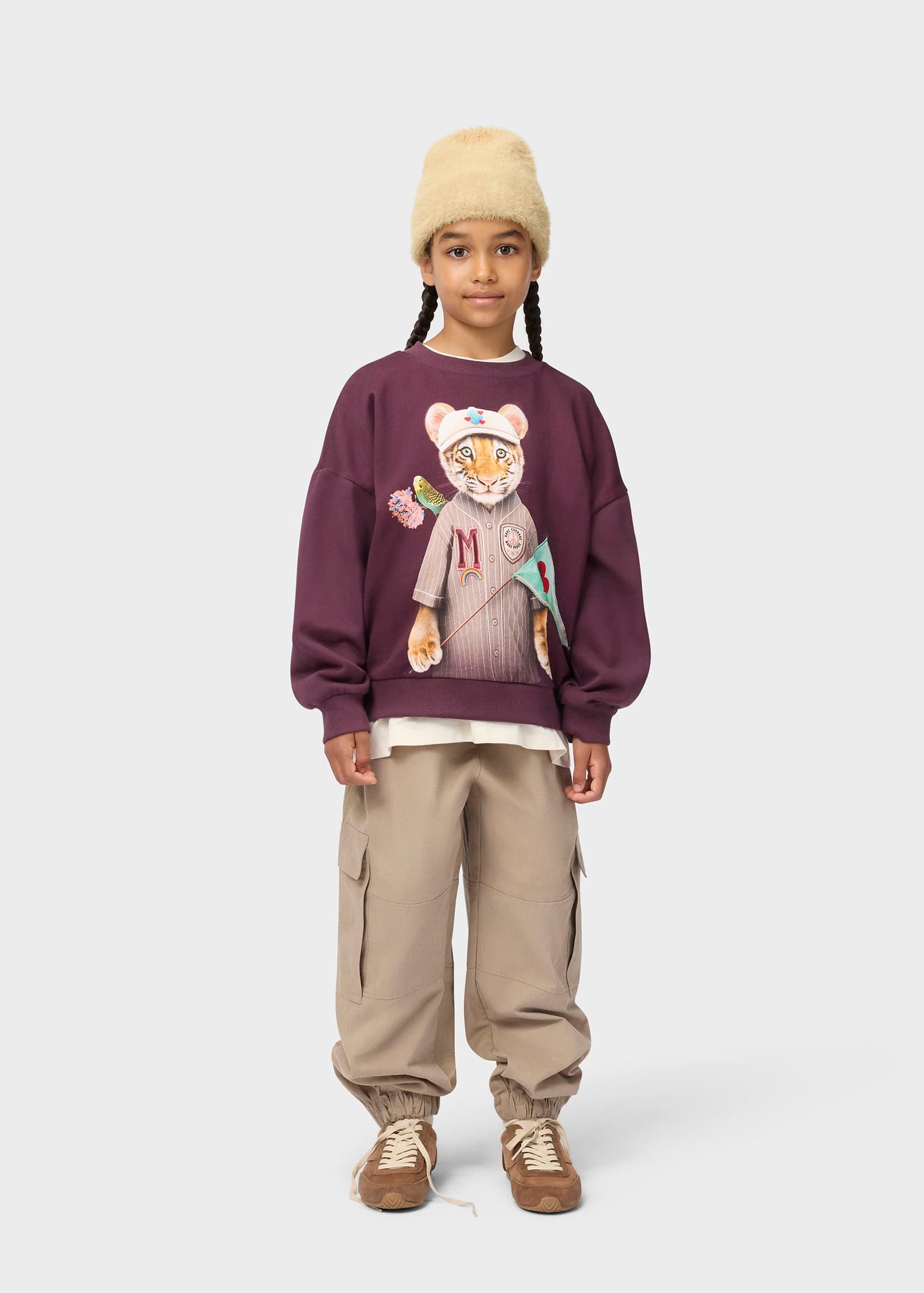Child wearing a sweater with a graphic design on a white background