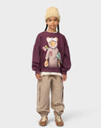 Child wearing a sweater with a graphic design on a white background