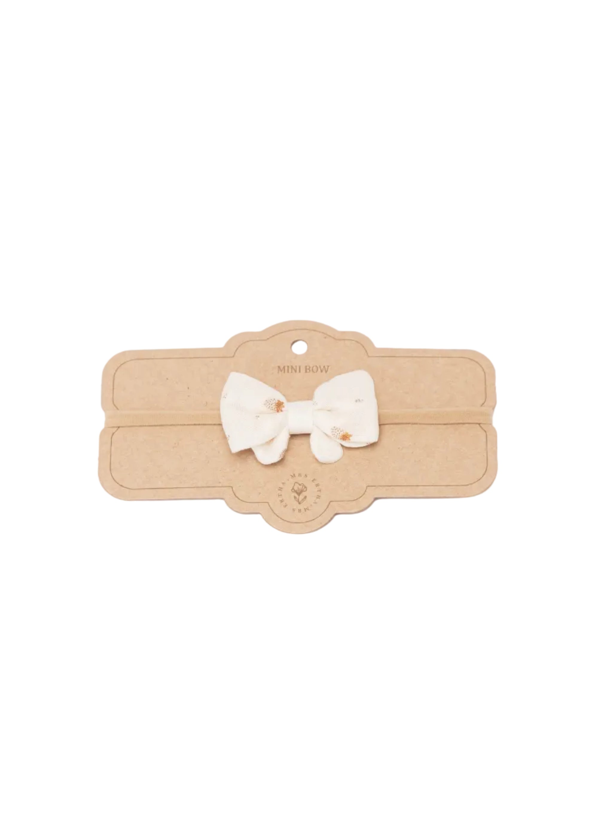 A small cream-colored fabric bow with tiny gold embroidered details, displayed on a brown kraft paper card labeled 'MINI BOW'.