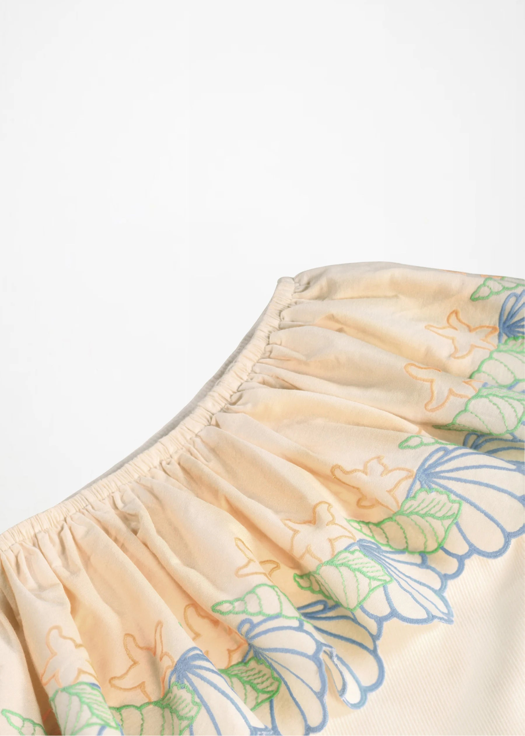 Beige shorts with floral embroidery on a white background