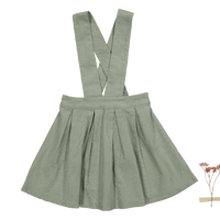 Green pleated skirt with suspenders on a white background