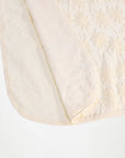 Close-up of a textured white fabric with a subtle pattern on a white background