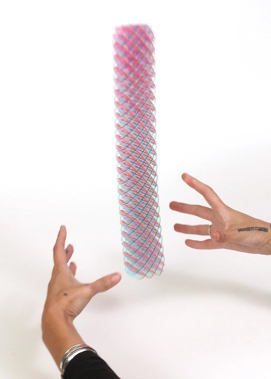 Colorful cylindrical object held by two hands against a white background