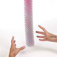 Colorful cylindrical object held by two hands against a white background