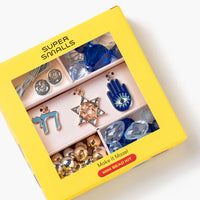 Yellow box containing colorful jewelry pieces with 'Super Smalls' branding.