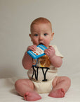 Baby holding a colorful book against a plain background