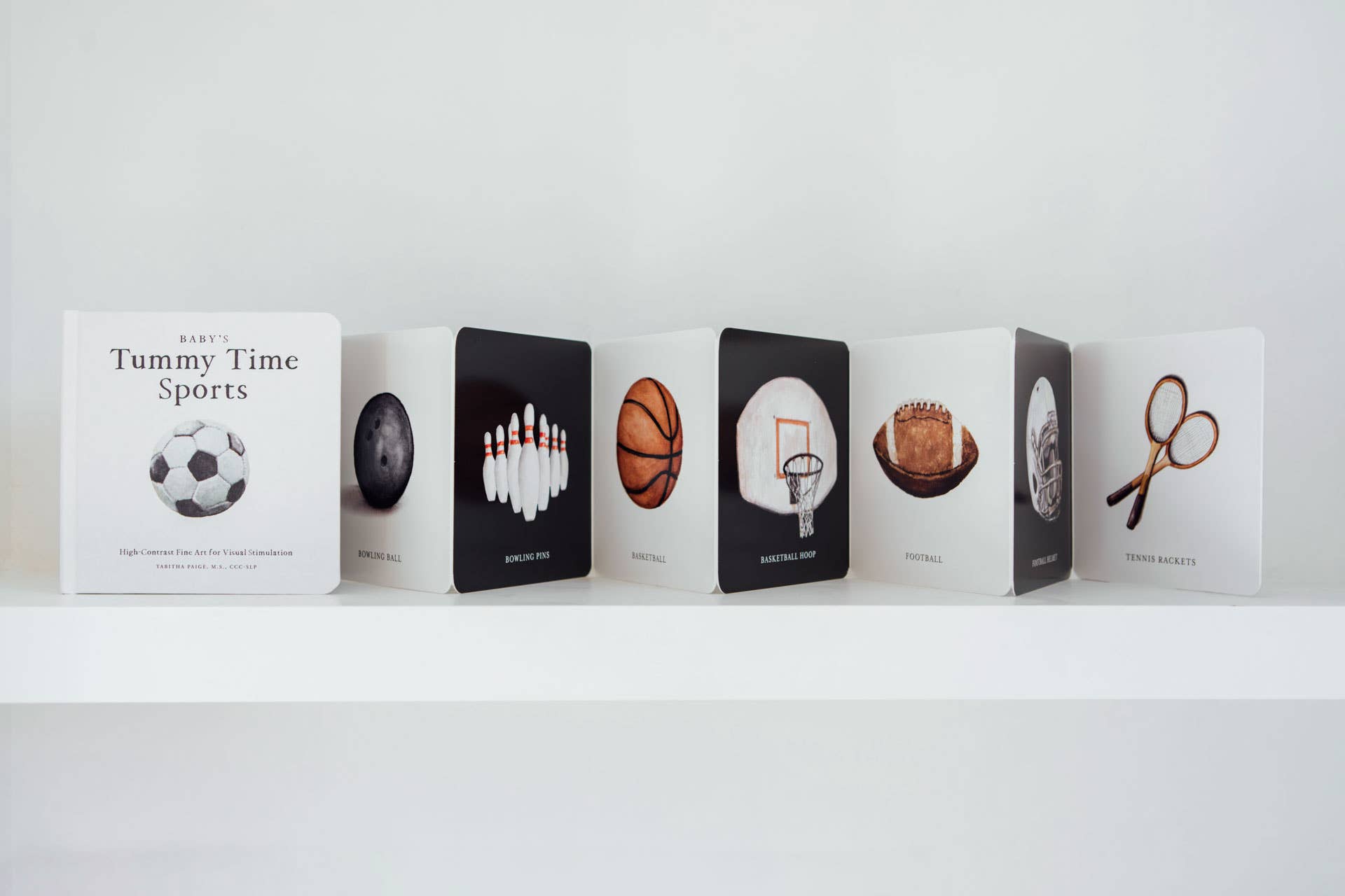 Row of books with sports-themed illustrations on a white shelf