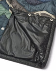Close-up of a black quilted jacket with visible stitching and buttons on a white background