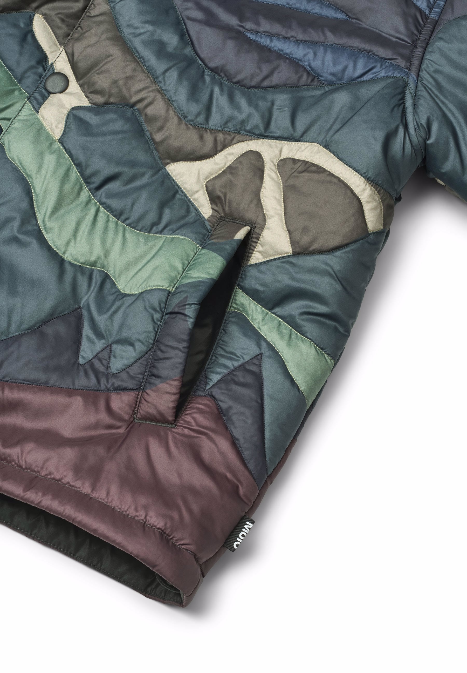 Close-up of a multicolored quilt with green, brown, and gray patterns on a white background.