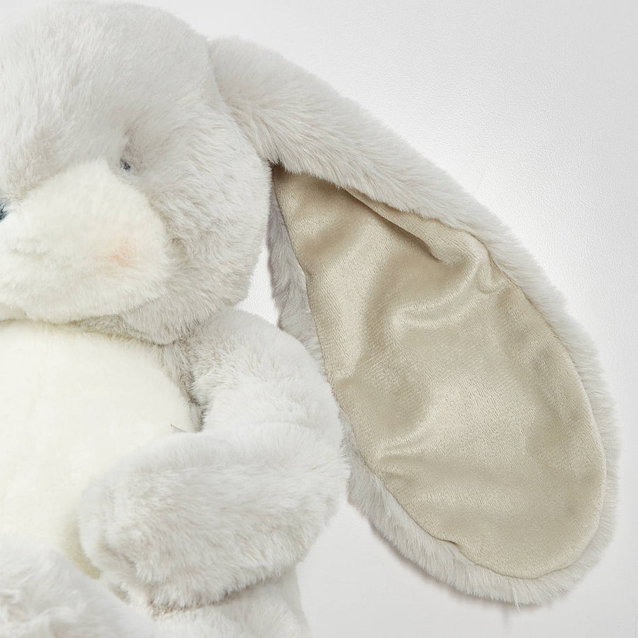 Close-up of a plush white bunny toy on a light background