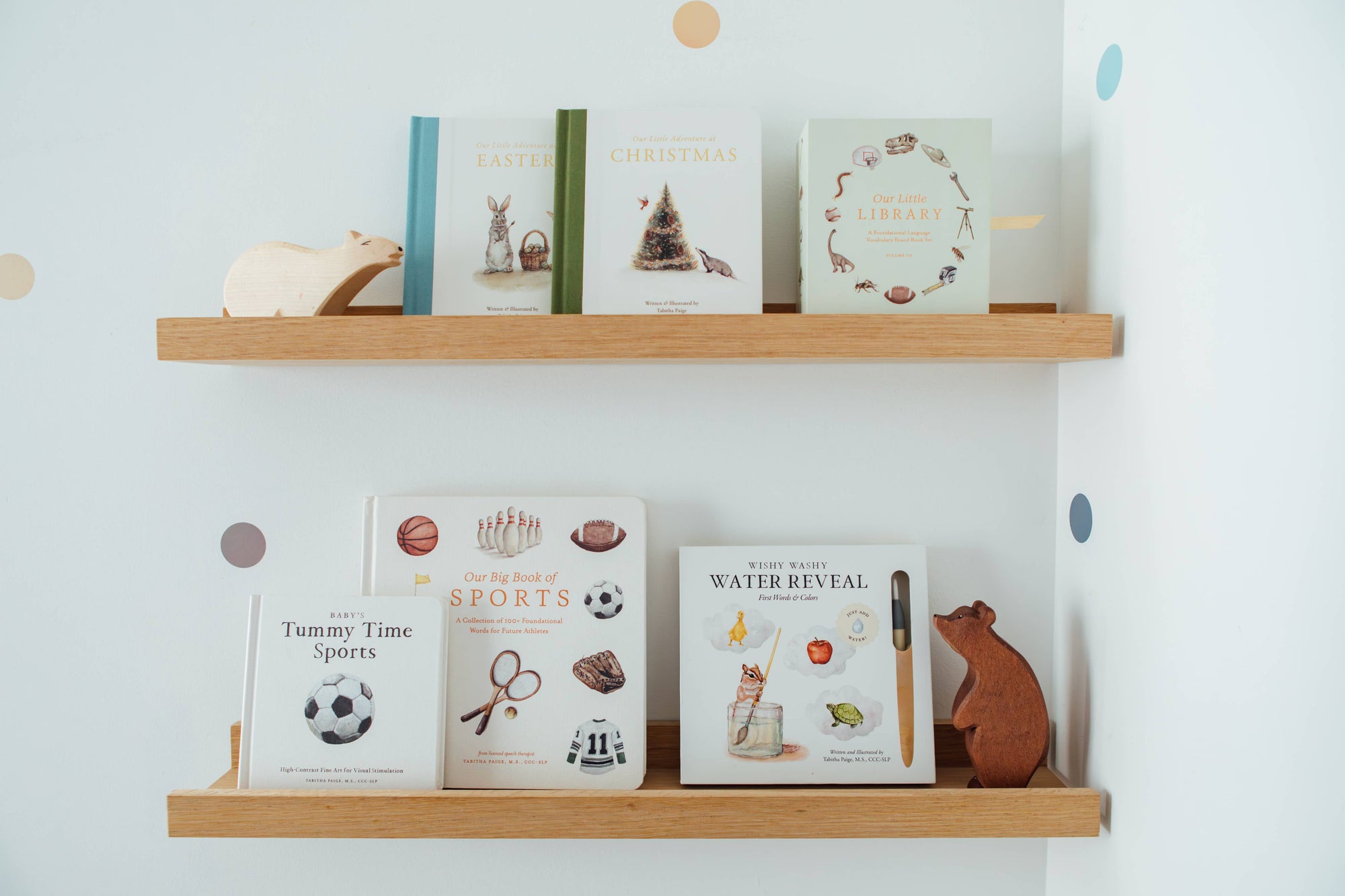 Wooden shelves with children's books and toys against a light blue wall.