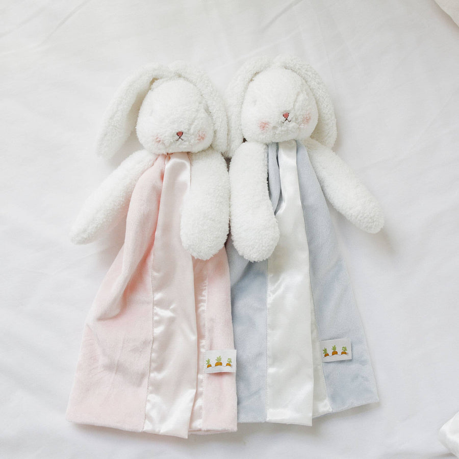 Two plush bunny toys with pink and gray blankets on a white background