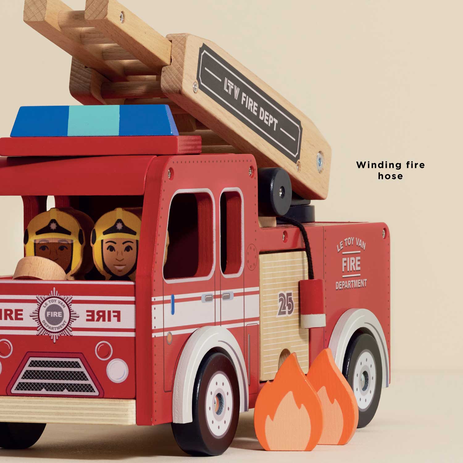 Toy fire truck with wooden ladder and toy figures inside, on a beige background.