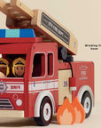 Toy fire truck with wooden ladder and toy figures inside, on a beige background.