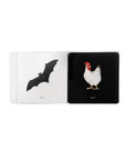 Open book with illustrations of a bat and a hen on black pages.
