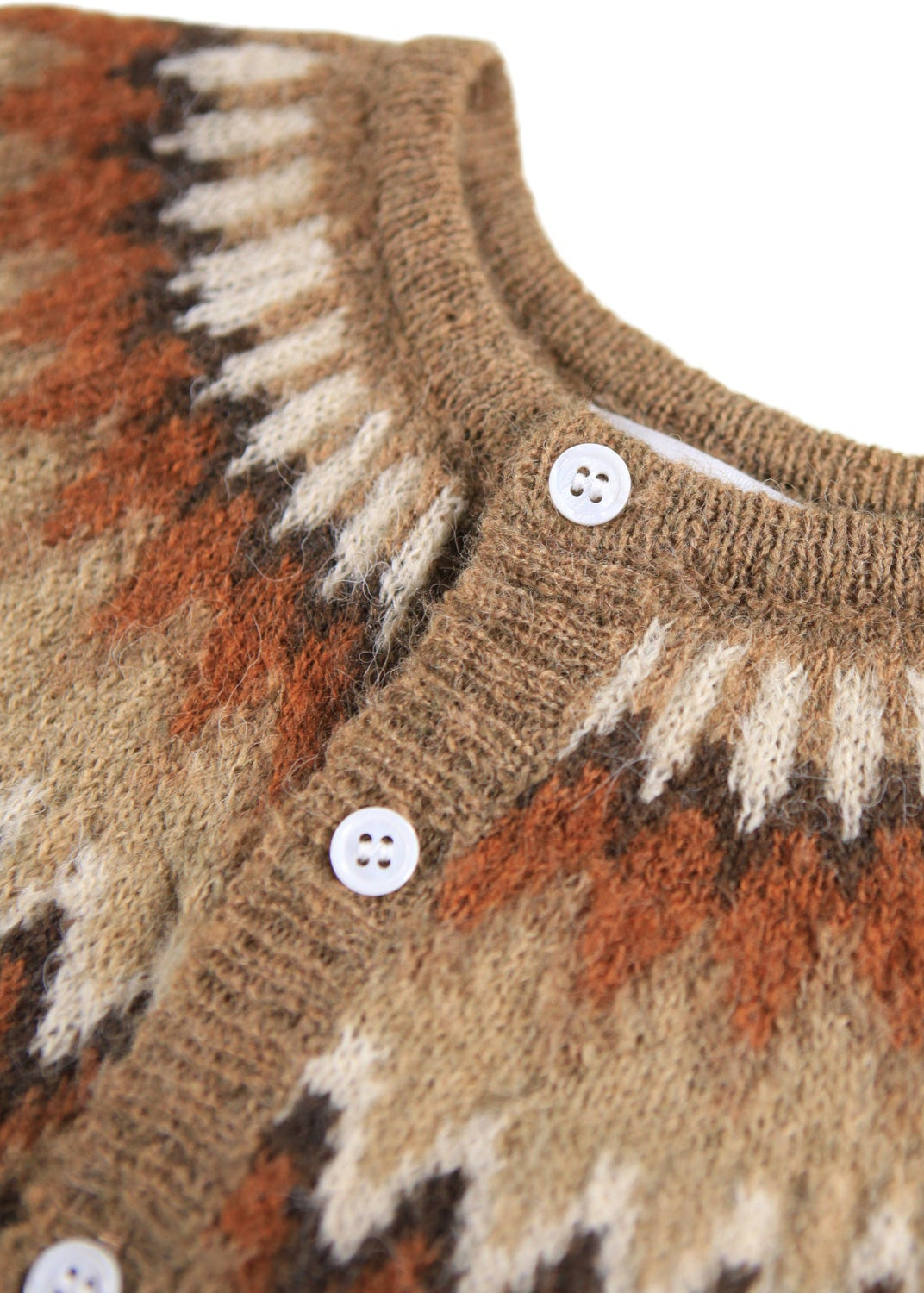 Close-up of a patterned sweater with buttons on a white background