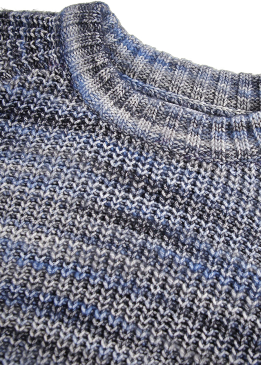 Close-up of a knitted sweater with a blue and gray pattern on a white background
