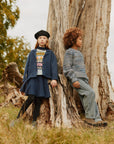 Two children sitting on a tree stump in a natural setting