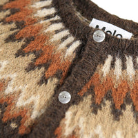 Close-up of a patterned sweater with buttons and a visible brand label.