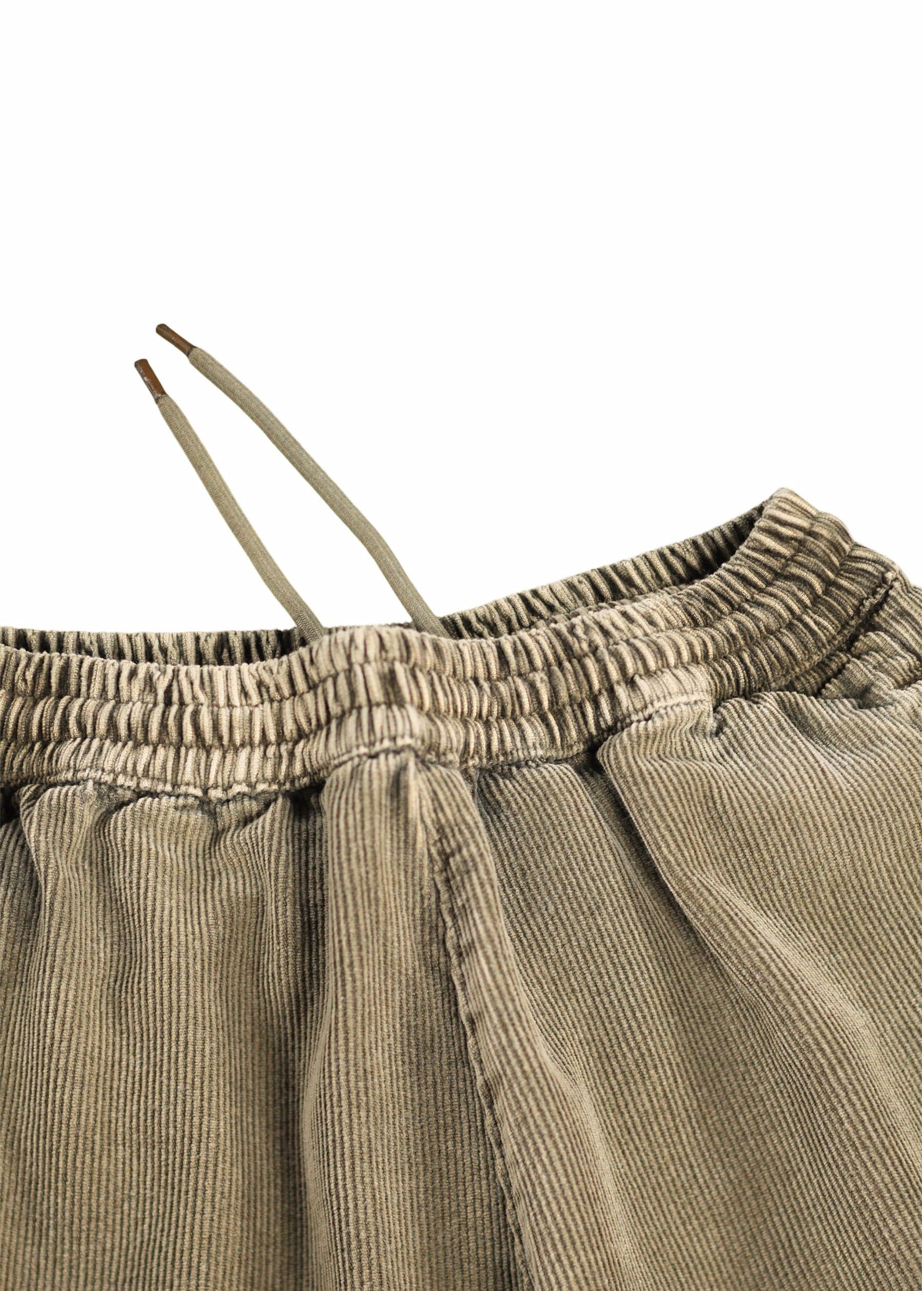 Close-up of beige corduroy pants with a white background