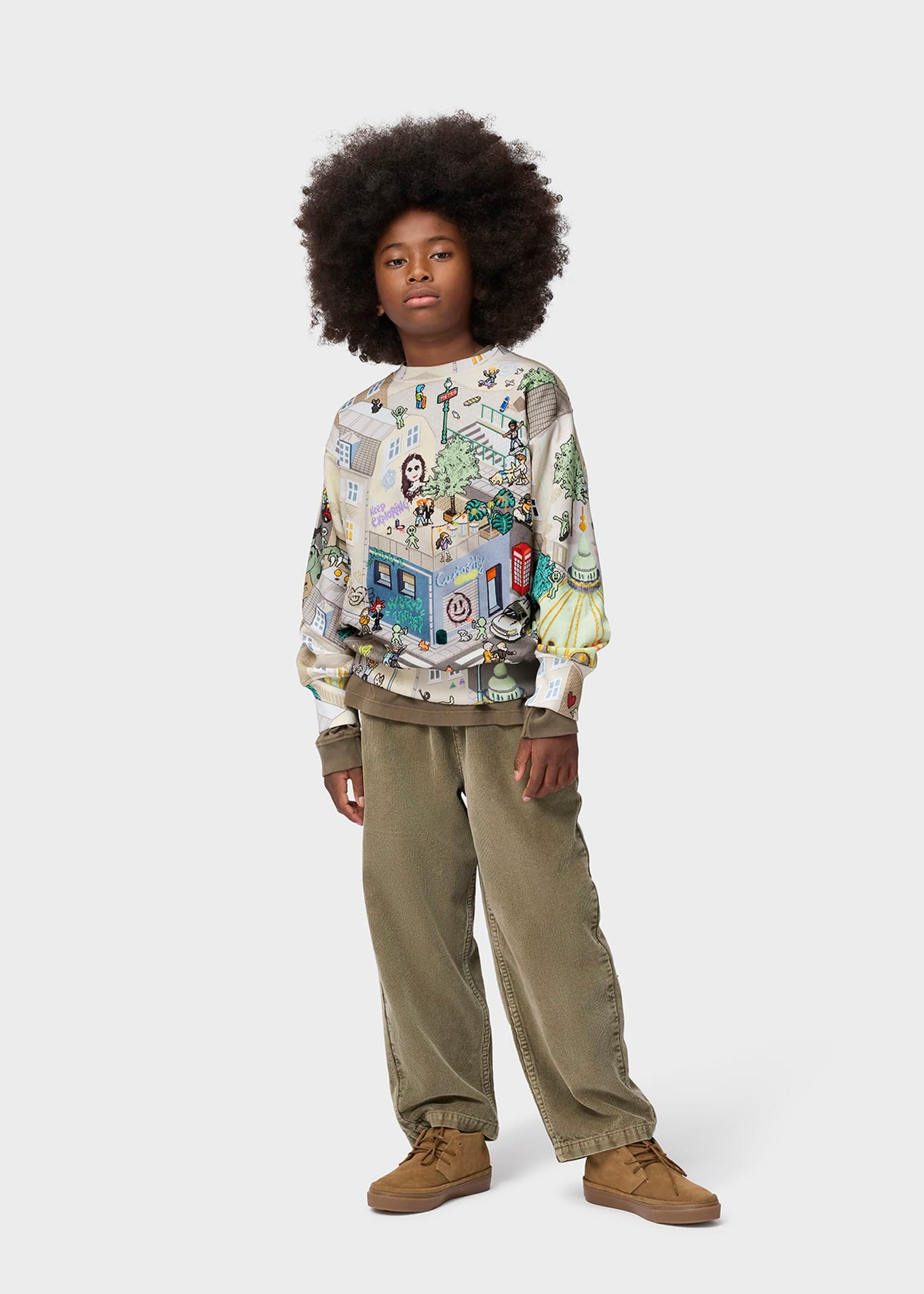 Person wearing a patterned sweater and beige pants on a white background